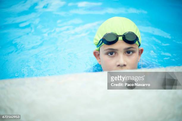 hispanic boy swimming with swimming cap and goggles - boy swimming pool goggle and cap stockfoto's en -beelden