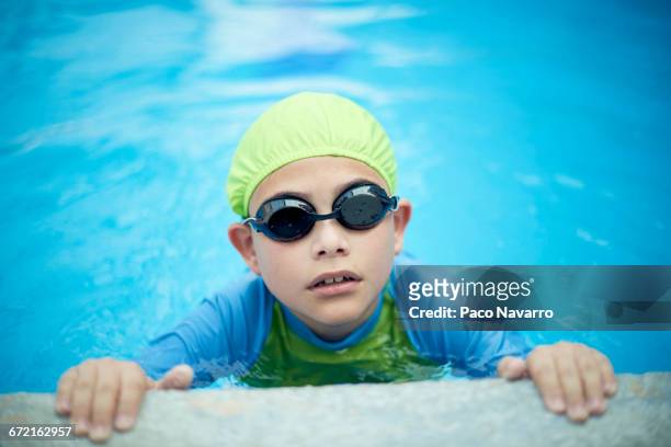 hispanic boy swimming with swimming cap and goggles - boy swimming pool goggle and cap stock pictures, royalty-free photos & images