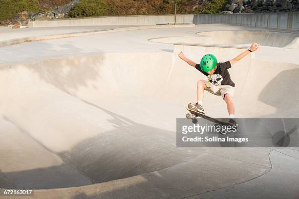 mixed race boy skateboarding in skate park - skateboard fall stock-fotos und bilder