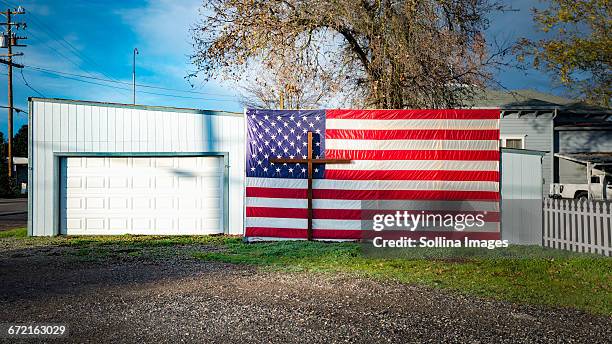 crucifix and american flag at garage - christianity stock pictures, royalty-free photos & images