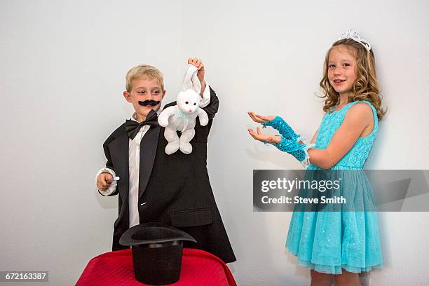 caucasian magician pulling rabbit from hat - boy tiara stock pictures, royalty-free photos & images