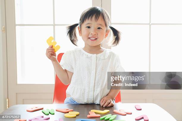 girl playing with alphabet toy - 日本人　英語 ストックフォトと画像