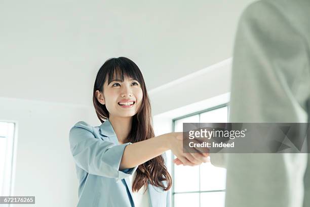 young businesswoman shaking hand  - japanese greeting stock pictures, royalty-free photos & images
