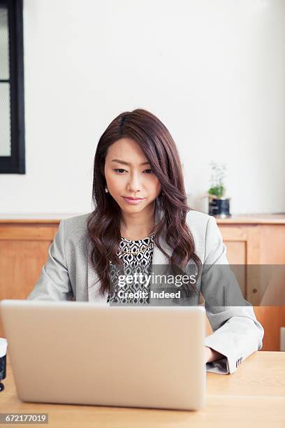young businesswoman using laptop - japanese people typing stock pictures, royalty-free photos & images