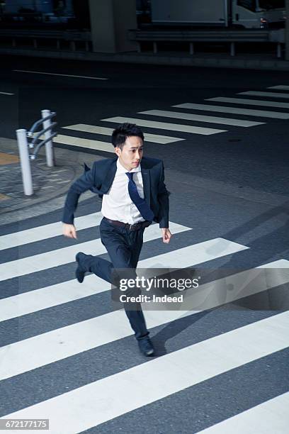 young businessman running on crossroad - asian man suit stock pictures, royalty-free photos & images