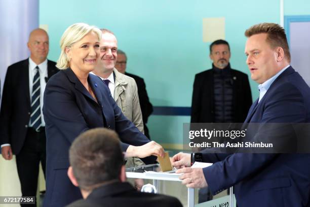 National Front Leader Marine Le Pen casts her vote for the French elections into the ballot box at a polling station on April 23, 2017 in Henin...
