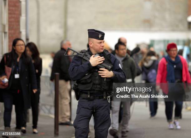 An armed police officer patrols near a polling station on April 23, 2017 in Henin Beaumont, France. The country will vote in a second round of...