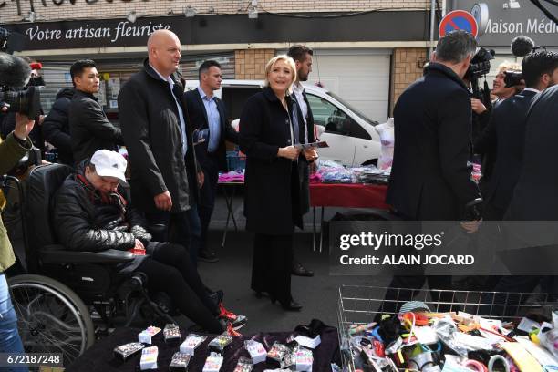 French presidential election candidate for the far-right Front National party Marine Le Pen , escorted by her bodyguard Thierry Legier tours the...