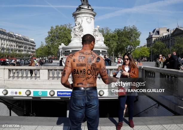 Man with his body covered with racist insults gives a flyer to a woman during an event organized by the Conseil Representatif des Associations Noires...
