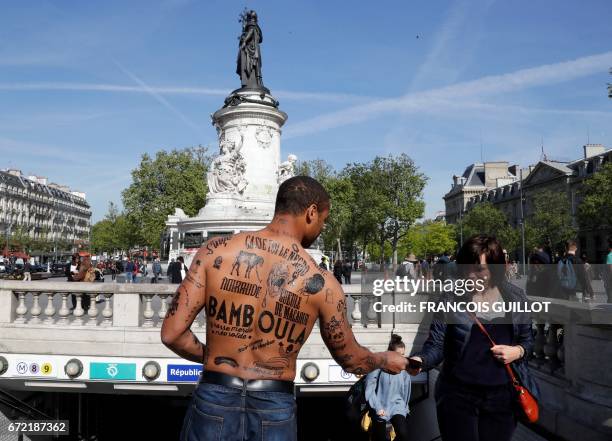 Man with his body covered with racist insults gives a flyer to a woman during an event organized by the Conseil Representatif des Associations Noires...