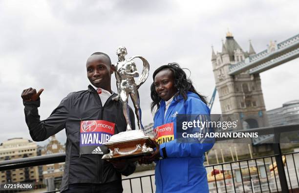 Kenya's Daniel Wanjiru and Mary Keitany pose with the trophy during a photocall beside Tower Bridge, the day after winning the men's and women's...