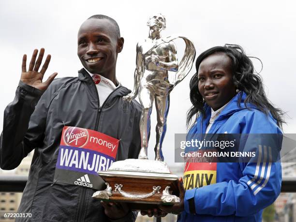 Kenya's Daniel Wanjiru and Mary Keitany pose with the trophy during a photocall beside Tower Bridge, the day after winning the men's and women's...
