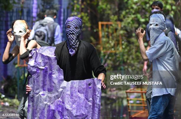 Kashmiri students wearing face masks look towards Indian government forces during clashes in central Srinagar's Lal Chowk on April 24, 2017. Police...