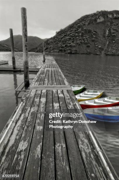 scenic view of pyramid lake with mountains, pier and boats with selective color tied up. - isolated colour stock-fotos und bilder