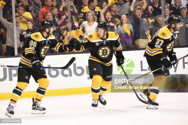 David Pastrnak, Charlie McAvoy and Patrice Bergeron of the Boston Bruins celebrate a goal against the Ottawa Senators in Game Six of the Eastern...