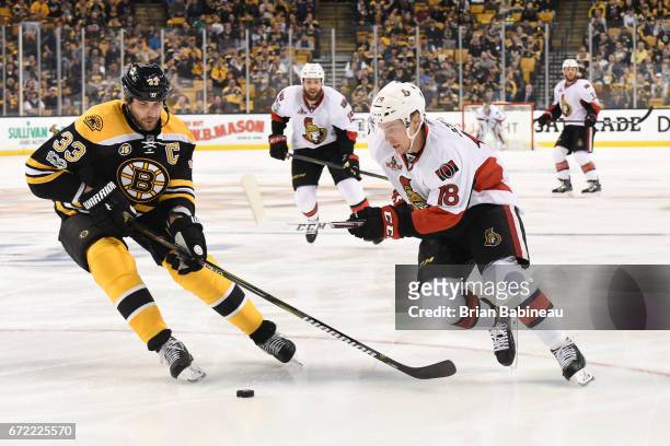 Zdeno Chara of the Boston Bruins fights with the puck against Ryan Dzingel of the Ottawa Senators in Game Six of the Eastern Conference First Round...