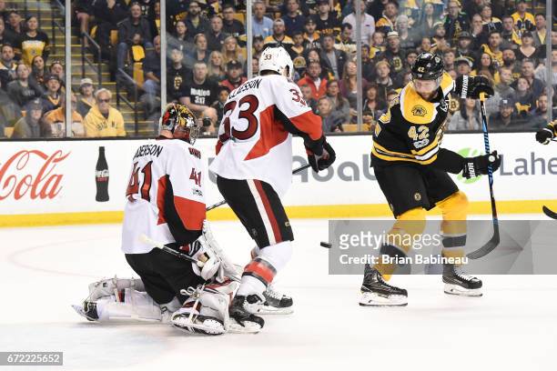 David Backes of the Boston Bruins watches the incoming puck against Craig Anderson and Fredrik Claesson of the Ottawa Senators in Game Six of the...