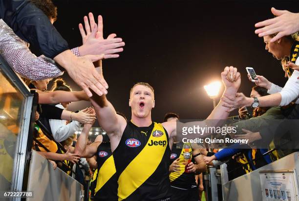 Josh Caddy of the Tigers high fives fans after winning the round five AFL match between the Richmond Tigers and the Melbourne Demons at Melbourne...