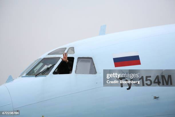 Aircrew wave from the open cockpit window of a Tupolev Ty-154M aircraft displaying a Russian national flag at Domodedovo Airport ZAO in Domodedovo,...