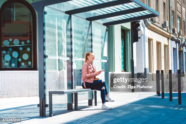 hermosa joven estudiante en el vidrio hecho cobertizo - waiting fotografías e imágenes de stock