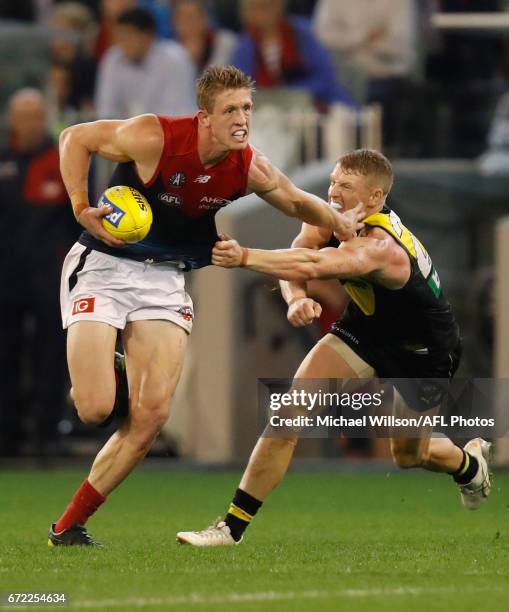 Sam Frost of the Demons fends off Josh Caddy of the Tigers during the 2017 AFL round 05 match between the Richmond Tigers and the Melbourne Demons at...