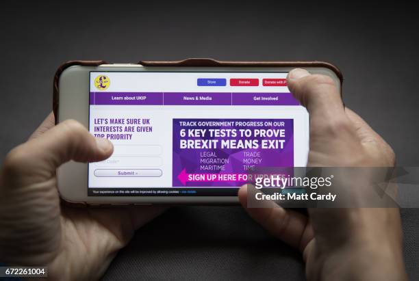 In this photo illustration a woman looks at the UKIP party mobile website on a iPhone on April 24, 2017 in Bristol, England. The use of digital...