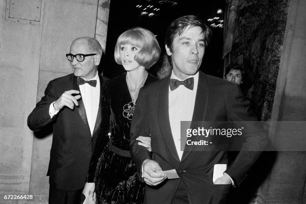 French actor Alain Delon , his wife French actress Mireille Darc and Georges Cravenne, leave Paris Opera House on October 15, 1968 after viewing la...