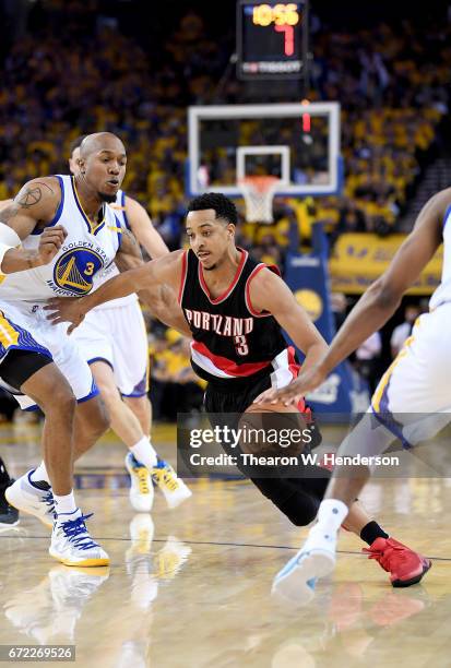 McCollum of the Portland Trail Blazers drives to the basket on David West of the Golden State Warriors in the fourth quarter during Game One of the...