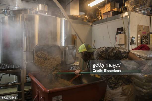 Worker cleans out spent grain from a machine at the Other Half Brewing Co. In the Gowanus neighborhood in the Brooklyn borough of New York, U.S., on...