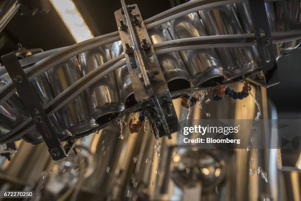 Beer cans pass through an Iron Heart Canning Co. Mobile canning machine at the Other Half Brewing Co. In the Gowanus neighborhood in the Brooklyn...