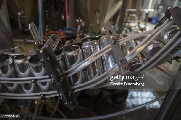 Beer cans pass through an Iron Heart Canning Co. Mobile canning machine at the Other Half Brewing Co. In the Gowanus neighborhood in the Brooklyn...