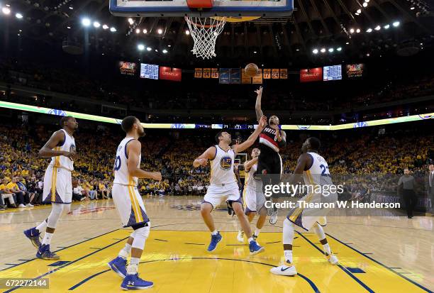 Damian Lillard of the Portland Trail Blazers shoots over Zaza Pachulia of the Golden State Warriors in the third quarter during Game One of the first...