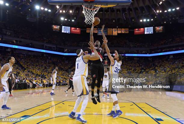 Maurice Harkless of the Portland Trail Blazers goes up to shoot over Stephen Curry and JaVale McGee of the Golden State Warriors in the third quarter...
