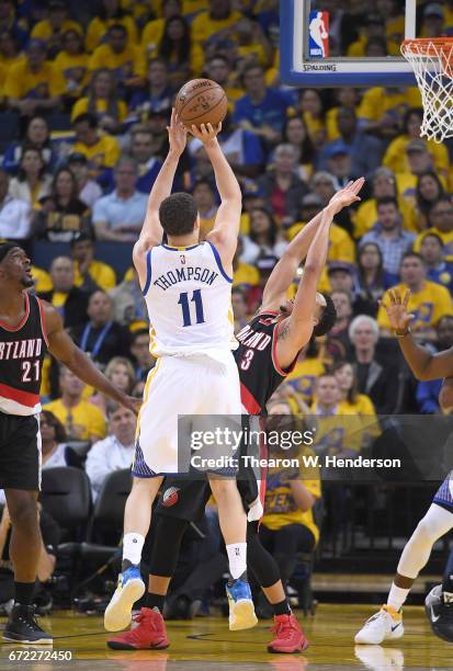 Klay Thompson of the Golden State Warriors shoots over CJ McCollum of the Portland Trail Blazers in the third quarter during Game One of the first...