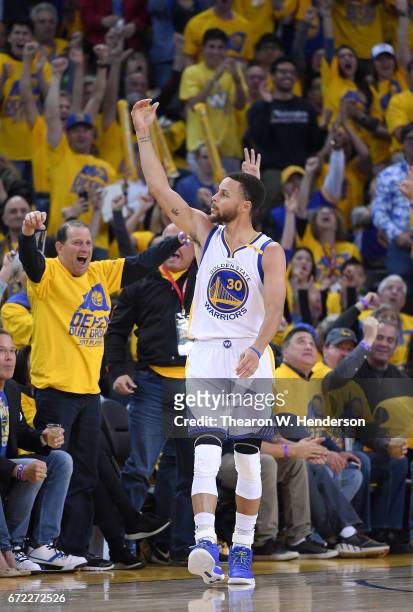 Stephen Curry of the Golden State Warriors reacts after making a three-point shot over Maurice Harkless of the Portland Trail Blazers in the third...