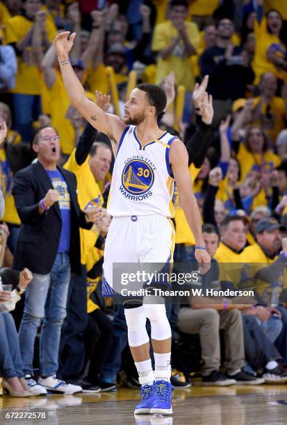 Stephen Curry of the Golden State Warriors reacts after making a three-point shot over Maurice Harkless of the Portland Trail Blazers in the third...