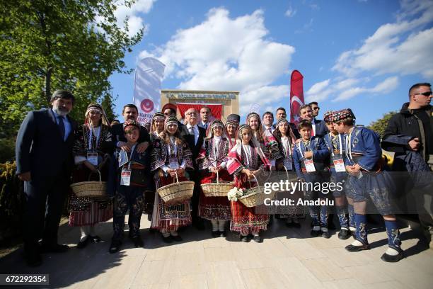 Turkish Culture and Tourism Minister Nabi Avci poses for a photo with kids wearing traditional costumes during the ceremony marking the 102nd...