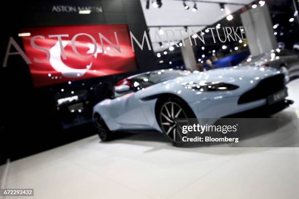 An Aston Martin DG11 luxury automobile, manufactured by Aston Martin Holdings UK Ltd., sits on display beneath a Turkish national flag at the...