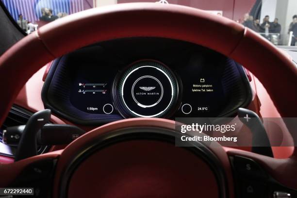 Digital dashboard display sits behind the steering wheel of an Aston Martin V8 Vantage luxury automobile, manufactured by Aston Martin Holdings UK...