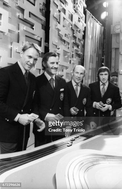 Portrait of Dan Gurney, Graham Hill, Sterling Moss and Jackie Stewart posing in front of a model car racing track on the set of the Ed Sullivan Show....