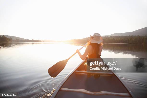 woman paddling into sunset on a lake in a canoe - paddla bildbanksfoton och bilder