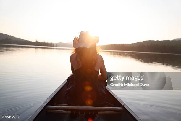 woman gazing upon a light-drenched lake - sun drenched stock pictures, royalty-free photos & images