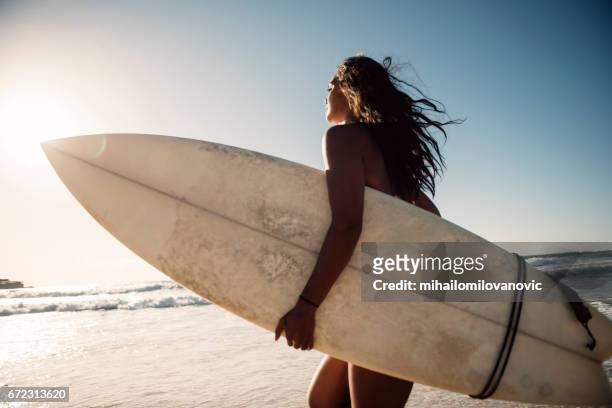donkere huid meisje surfer - woman surfboard stockfoto's en -beelden