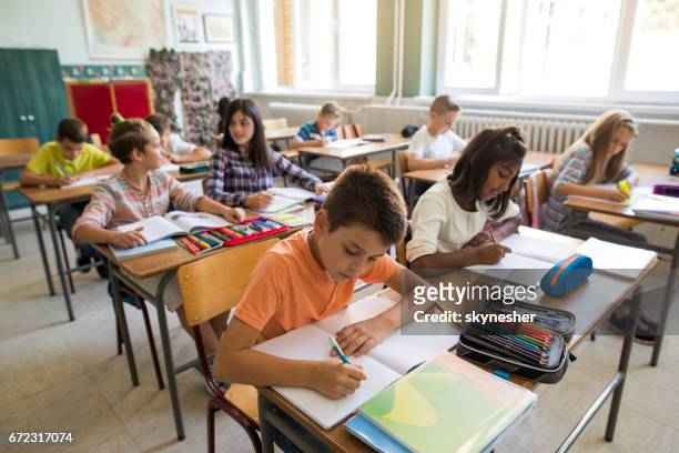 group of school children studying in the classroom. - 5-10 2016 stock pictures, royalty-free photos & images