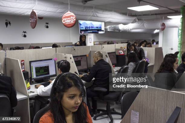 Employees work at the America Movil SAB Claro Colombia call center in Bogotá, Colombia, on Thursday, April 6, 2017. America Movil SAB is scheduled to...