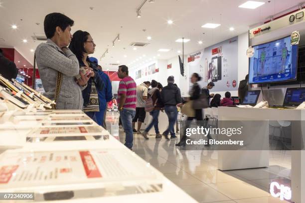 Customers view merchandise for sale at an America Movil SAB Claro Colombia store in Bogotá, Colombia, on Saturday, April 8, 2017. America Movil SAB...