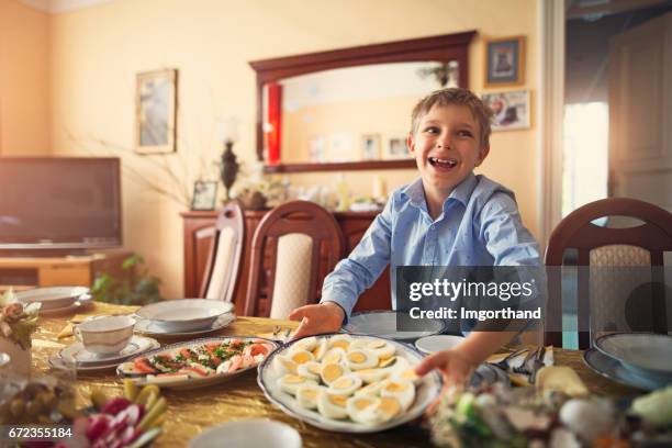 little boy setting the table for traditional easter breakfast - easter poland stock pictures, royalty-free photos & images