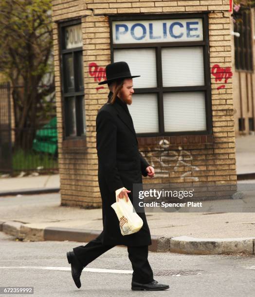 Hasidic man walks by a police outpost in a Jewish Orthodox neighborhood in Brooklyn on April 24, 2017 in New York City. According to a new report...