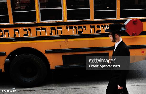 Hasidic man walks through a Jewish Orthodox neighborhood in Brooklyn on April 24, 2017 in New York City. According to a new report released by the...