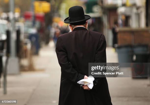 Hasidic man walks through a Jewish Orthodox neighborhood in Brooklyn on April 24, 2017 in New York City. According to a new report released by the...